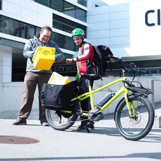 Lastenvelo mit Gepäck vor einem Bürogebäude